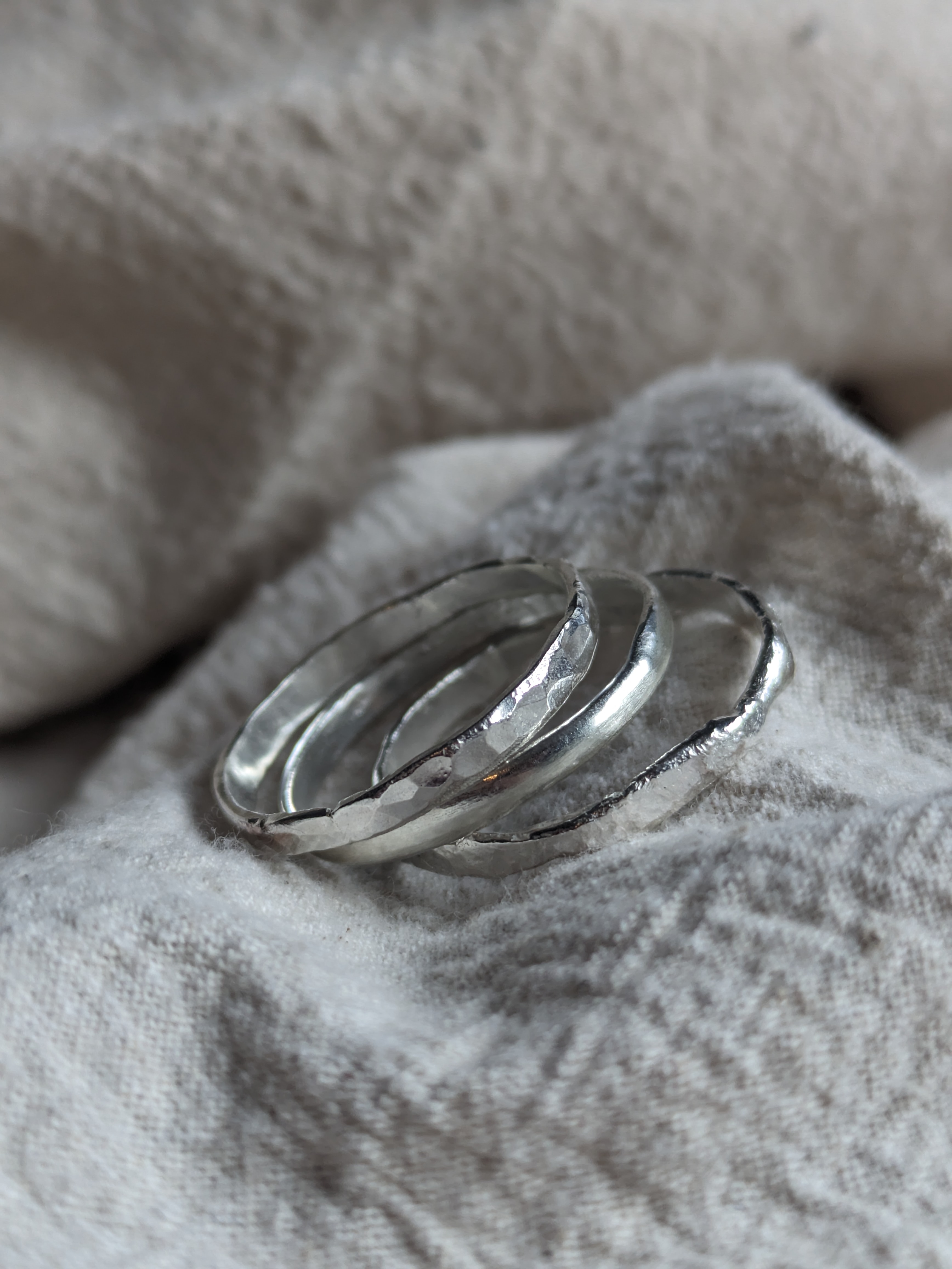 3 stacking rings made from silver on a canvas background