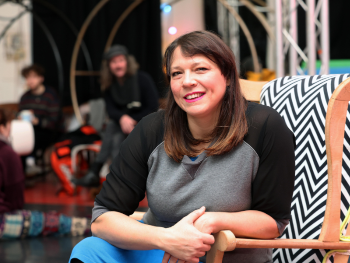 An image Bridie smiling to camera sat on a chair