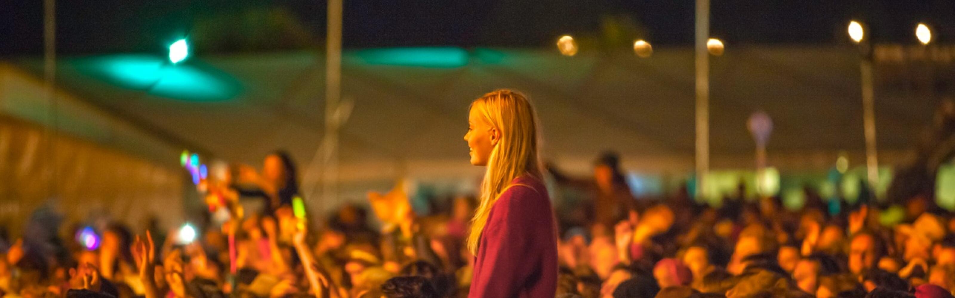 Gig crowd with blonde woman higher above