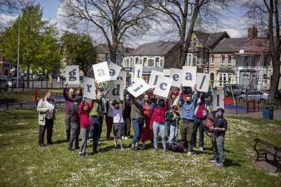 Gentle Radical holding up letters in Riverside - photo credit Michal Iwanowski